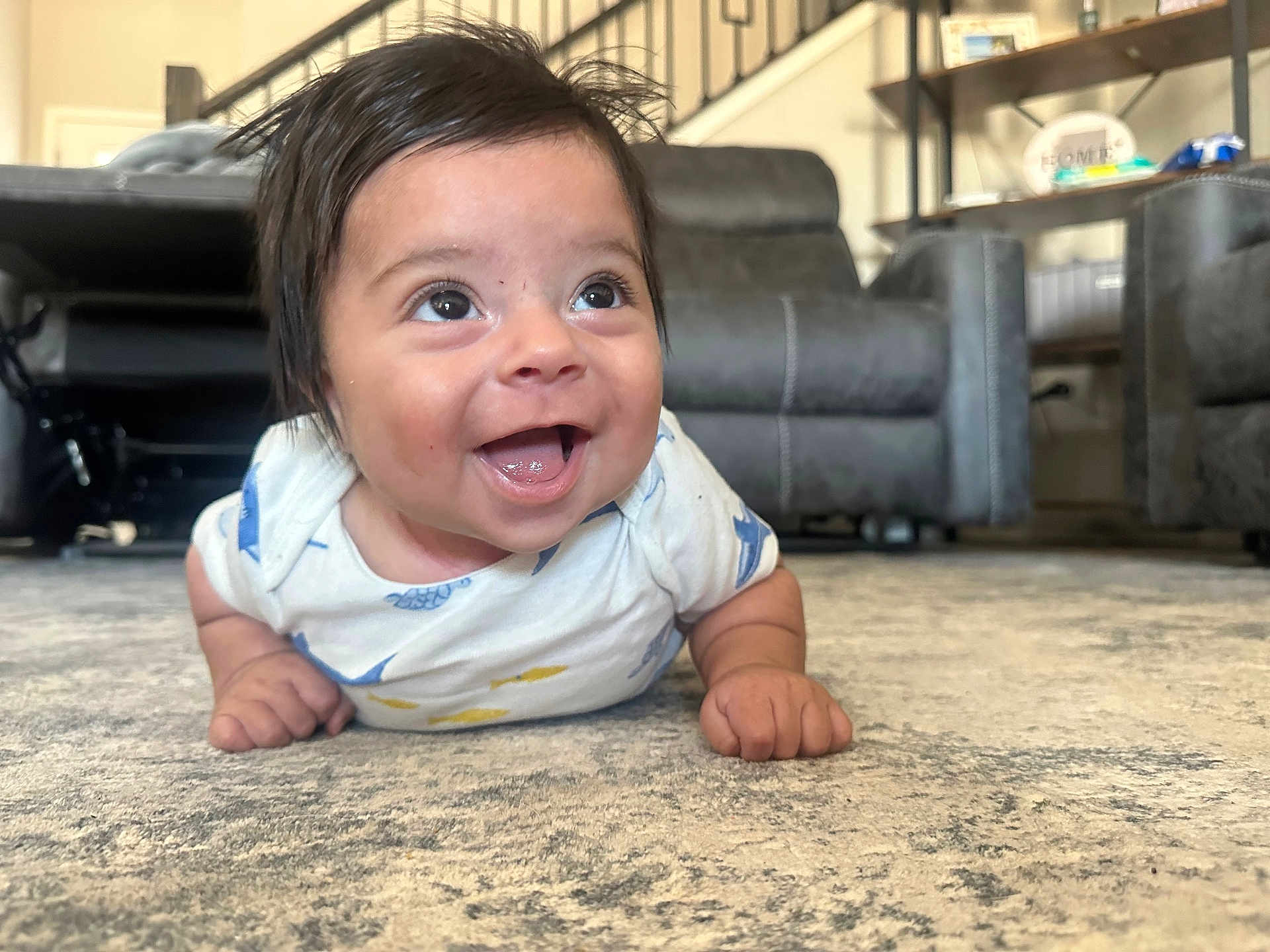 Asher joined the competition — help win amazing prizes! baby, smiling, happy, infant, carpet, indoor, living_room, furniture, couch, shelf, person, child, cute, toddler, clothing, home, expression, face, eyes, hands