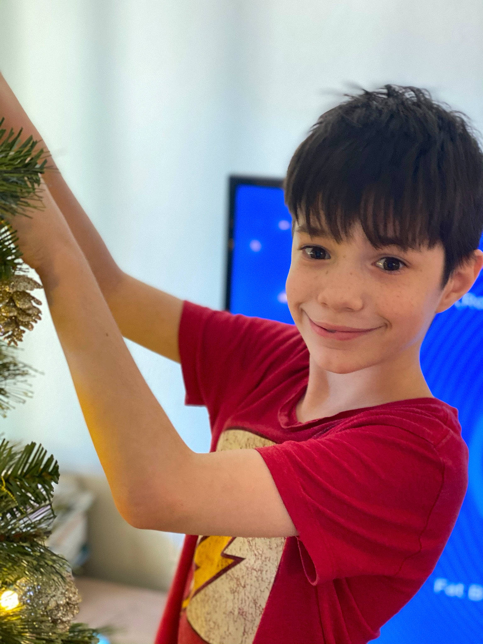 Noah is registered to the contest to win money with this photo: child, christmas_decoration, christmas_tree, conifer, elbow, electric_blue, event, evergreen, fir, fun, gesture, happy, human_body, human_leg, joy, leisure, ornament, person, room, sleeve
