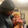 adult, affection, baby, baby_hat, bonnet, casual_wear, child, colorful_clothing, curious, facial_expression, family, holding, home_interior, indoor, love, man, person, portrait, smile, tattoo