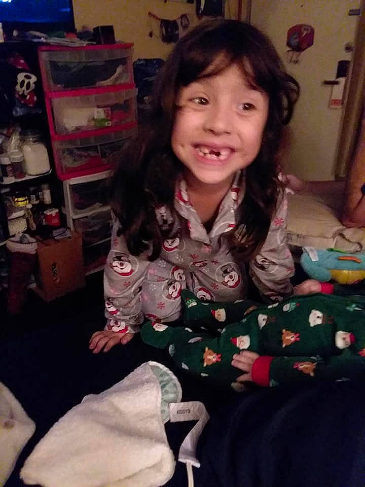 Isabella is registered to the contest to win money with this photo: black_hair, brown_hair, child, joy, long_hair, outerwear, pajamas, person, smile, toddler