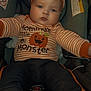 baby, child, car_seat, halloween, pumpkin, hat, striped_clothing, orange, black_pants, socks, face, person, infant, cute, expression, indoor, seatbelt, warning_label, reaching_out, portrait