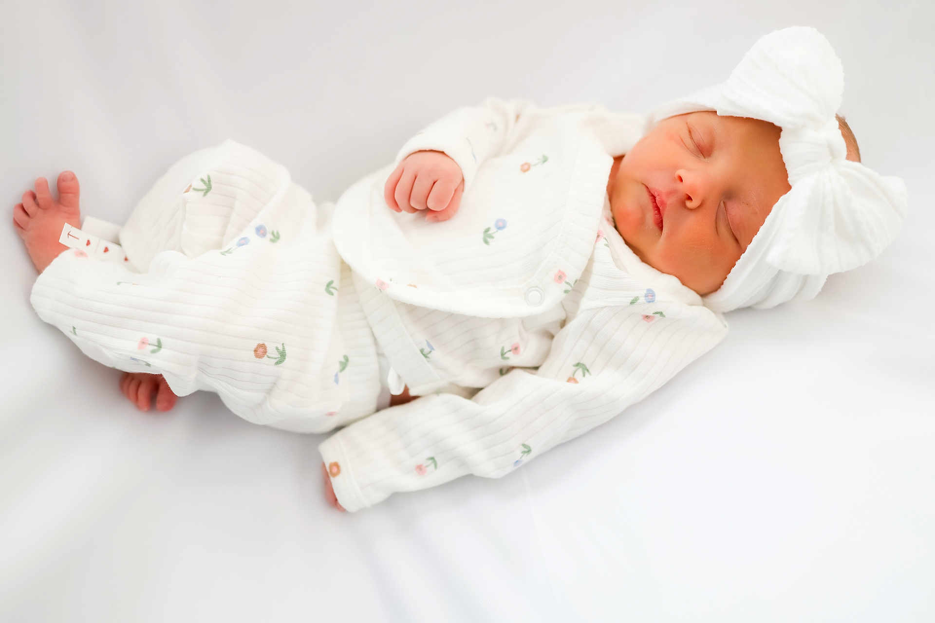 Oaklynn joined the competition — help win amazing prizes! newborn, baby, sleeping, pajamas, white_clothing, headband, bow, floral_pattern, infant, resting, soft_texture, cozy, blanket, cute, peaceful, child, portrait, indoors, small_hands, small_feet