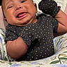 baby, blanket, child, close_up, clothing, crying, cute, expression, face, floral, indoor, infant, mittens, newborn, pattern, person, polka_dot, portrait, soft, tongue