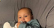 Kailo is registered to the contest to win money with this photo: baby, infant, pacifier, toy, bed, blanket, clothing, blue, gray, cute, child, indoors, young, comfort, sleepwear, person, skin, head, legs, relaxation