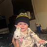 Kaylanna joined the competition — help win amazing prizes! baby, infant, child, portrait, smiling, wide_eyed, knit_hat, winter_clothing, pajamas, printed_clothing, sitting, being_held, hand, indoor, home, flash_photography, closeup, cozy, blanket, night