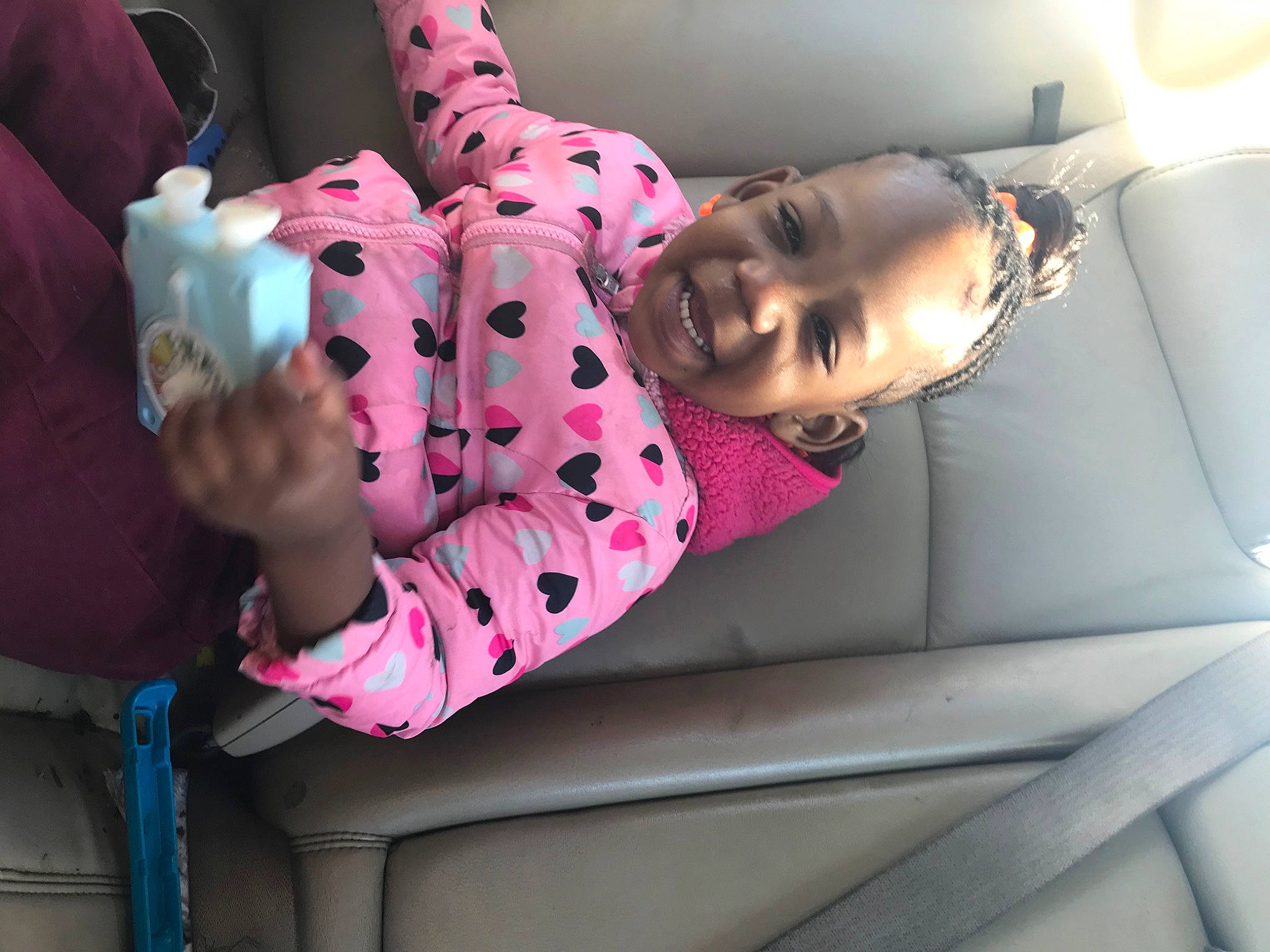 Kamiah is registered to the contest to win money with this photo: automotive_design, baby_toddler_clothing, beauty, child, comfort, couch, fun, human_leg, leisure, luxury_vehicle, magenta, pattern, person, pink, room, sitting, sleeve, smile, thigh, toddler