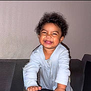 Melïan a rejoint le concours — aidez-le/la à gagner de superbes lots ! toddler, child, smiling, curly_hair, indoor, couch, happy, person, baby_clothes, face, home, furniture, joy, portrait, leaning, cute, young_child, light_skin, playful, expression