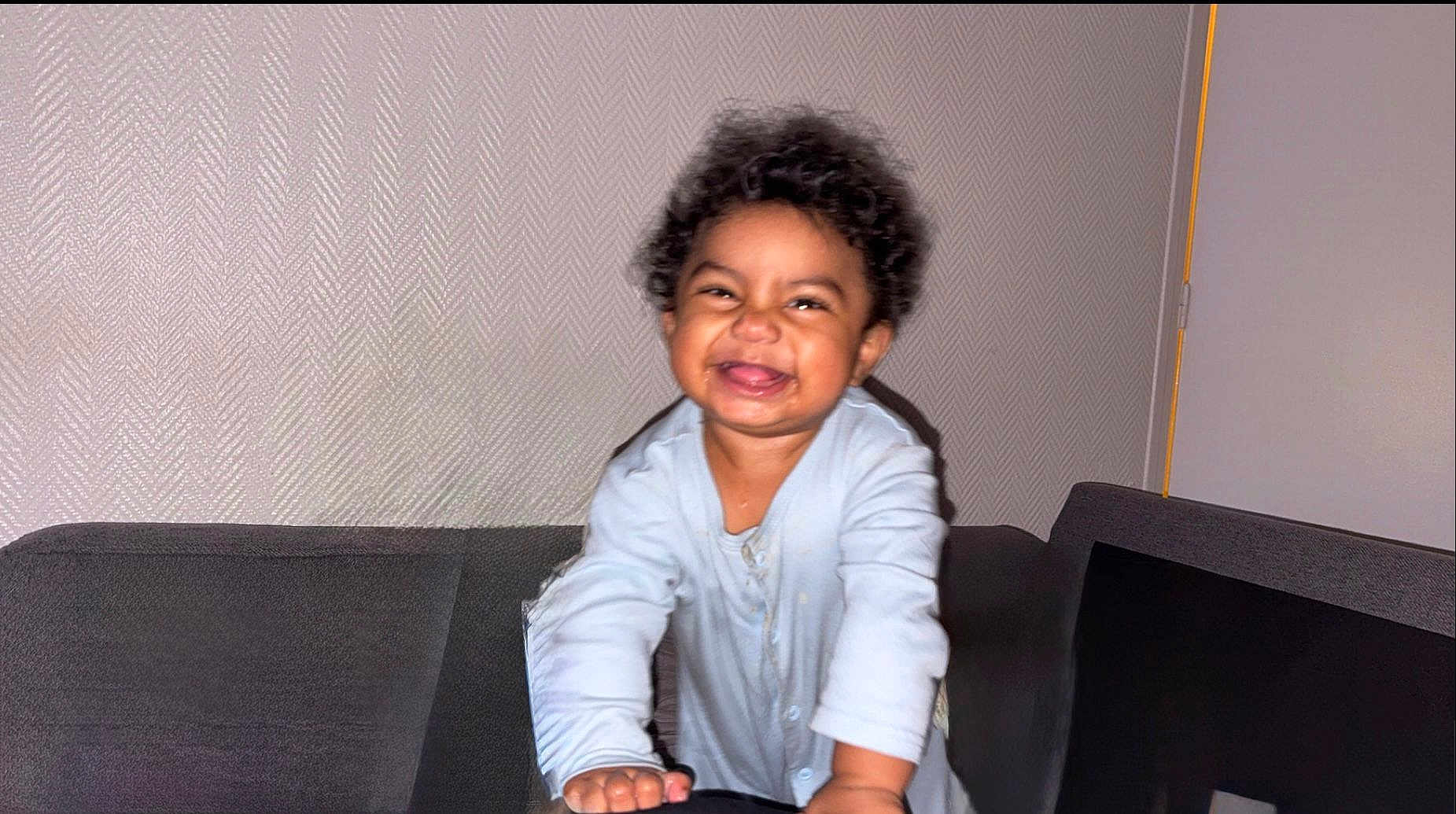 Melïan a rejoint le concours — aidez-le/la à gagner de superbes lots ! toddler, child, smiling, curly_hair, indoor, couch, happy, person, baby_clothes, face, home, furniture, joy, portrait, leaning, cute, young_child, light_skin, playful, expression