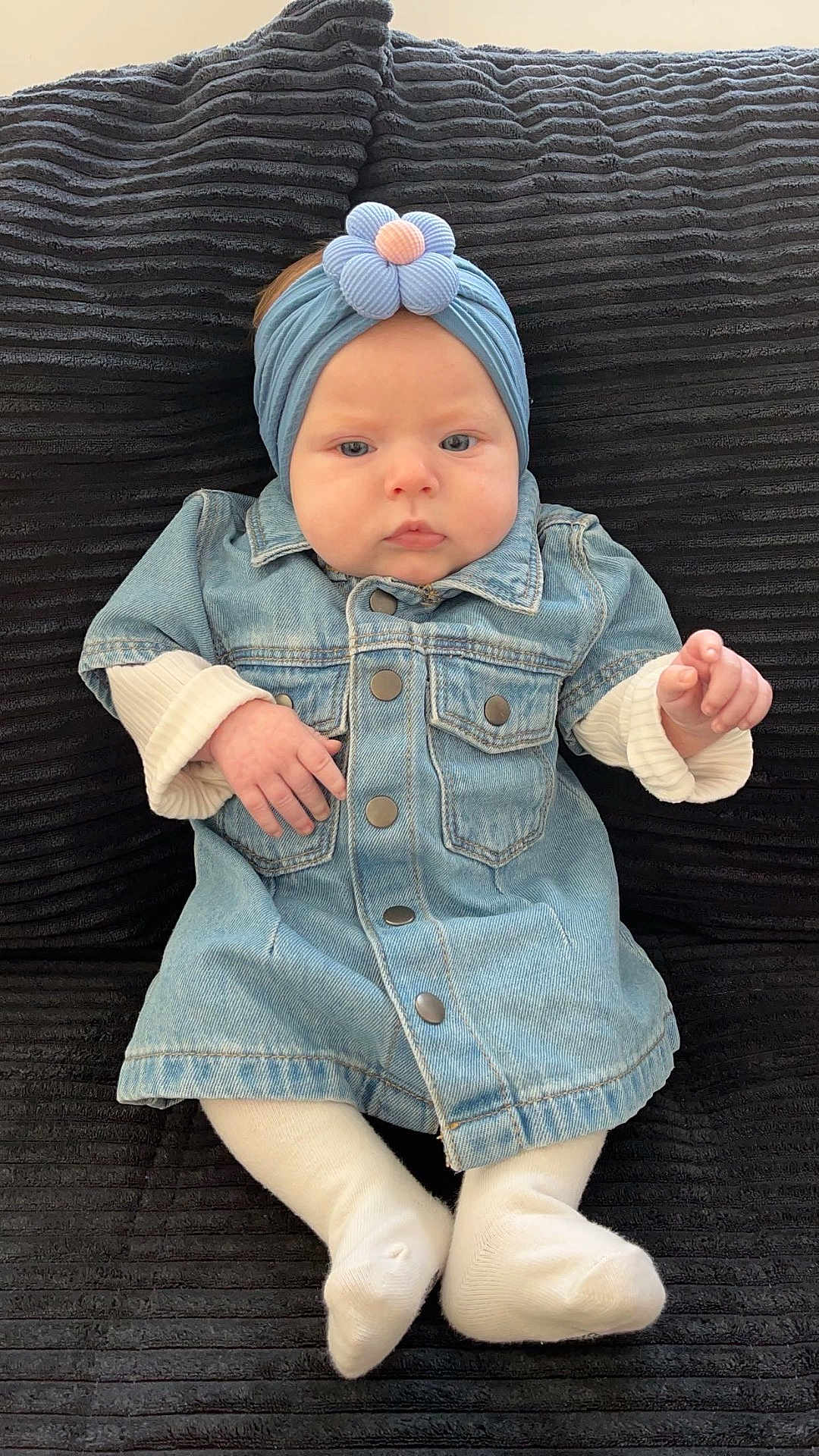 Zayli participe au concours pour gagner de l'argent avec cette photo : baby, denim_jacket, headband, flower, white_tights, infant, cushion, black_background, cute, child, portrait, indoor, fashion, apparel, seated, small_hands, expressionless, soft_lighting, casual, adorable