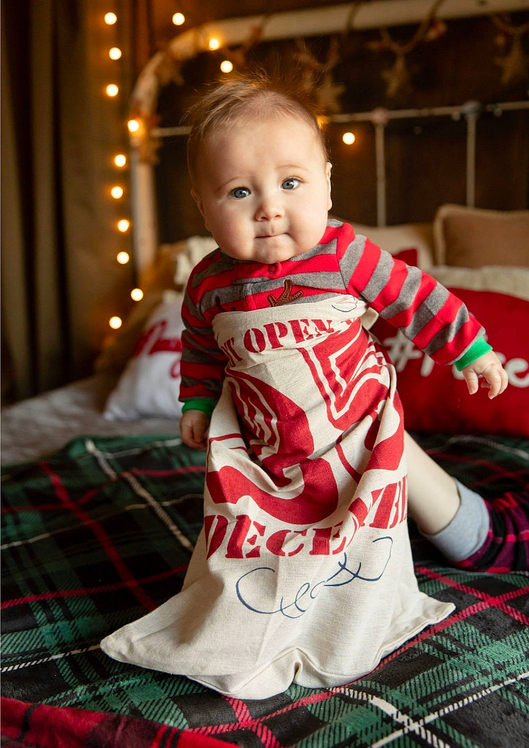 Dino is registered to the contest to win money with this photo: baby, child, christmas, christmas_decoration, christmas_eve, christmas_ornament, design, holiday, pajamas, pattern, person, plaid, sitting, sleeve, tartan, textile, toddler