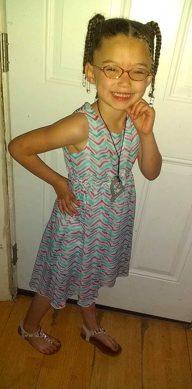 Anima is registered to the contest to win money with this photo: child, clothing, dress, eyewear, finger, glasses, joy, pattern, person, shoulder, smile, t_shirt, toddler, vision_care