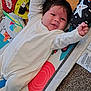 baby, infant, onesie, play_mat, colorful, smiling, happy, child, indoor, carpet, face, arms_raised, cute, young, person, lying_down, patterned, soft_toys, starfish, animal_prints