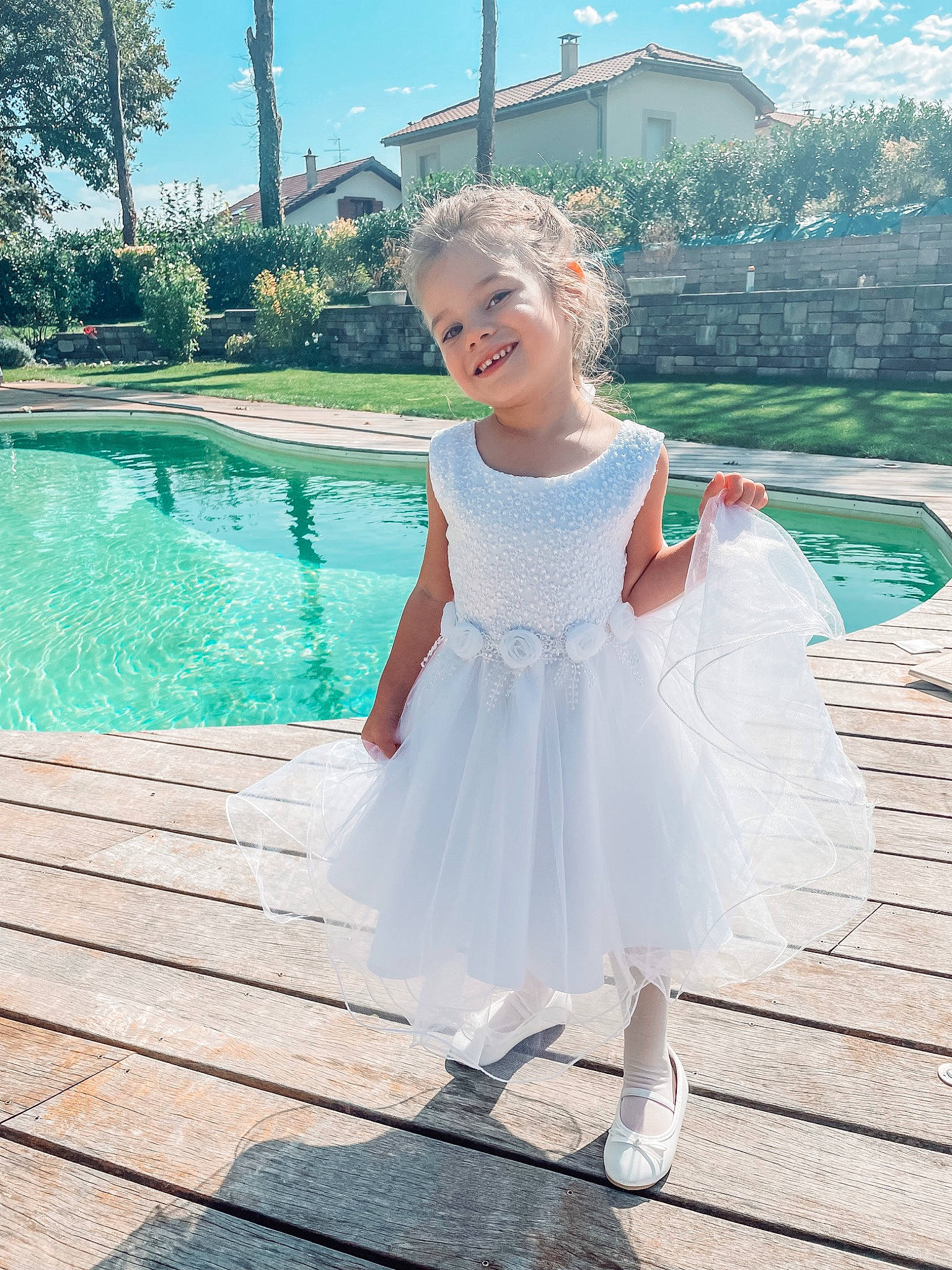 Lilou participe au concours pour gagner de l'argent avec cette photo : aqua, azure, bridal_clothing, bridal_party_dress, dress, formal_wear, fun, grass, happy, joy, leisure, one_piece_garment, person, plant, recreation, sky, sleeve, smile, swimming_pool, toddler