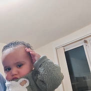 Jacob is registered to the contest to win money with this photo: baby, casual, child, cozy, curly_hair, cute, expression, face, fuzzy_clothing, hand, holding, home, indoor, person, portrait, small_child, sweater, toddler, warm_clothing, window