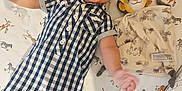 Jacob is registered to the contest to win money with this photo: baby, child, smiling, crib, plush_toy, simba, blanket, romper, checkered_clothing, animal_print, zebra, elephant, giraffe, lion, toddler, happy, indoor, cute, lying_down, nursery