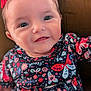 baby, child, smiling, face, clothing, dress, pattern, butterfly, floral, red_bow, cute, portrait, infant, person, happy, indoors, seated, head, skin, young