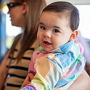 Andres joined the competition — help win amazing prizes! baby, child, woman, person, face, portrait, colorful_clothing, holding, indoor, blurred_background, cute, smiling, happy, casual_wear, watch, glasses, striped_shirt, long_hair, light, soft_focus