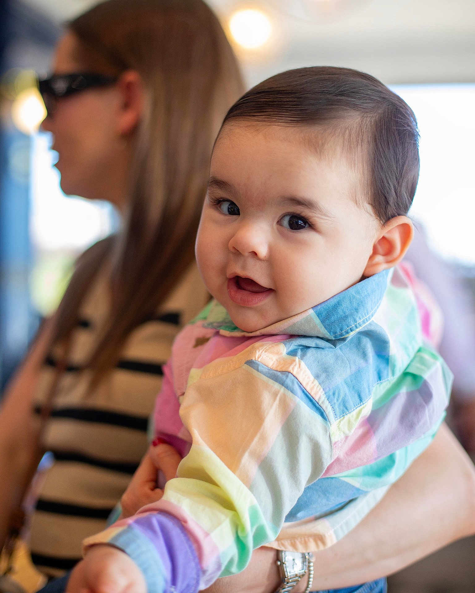 Andres joined the competition — help win amazing prizes! baby, child, woman, person, face, portrait, colorful_clothing, holding, indoor, blurred_background, cute, smiling, happy, casual_wear, watch, glasses, striped_shirt, long_hair, light, soft_focus