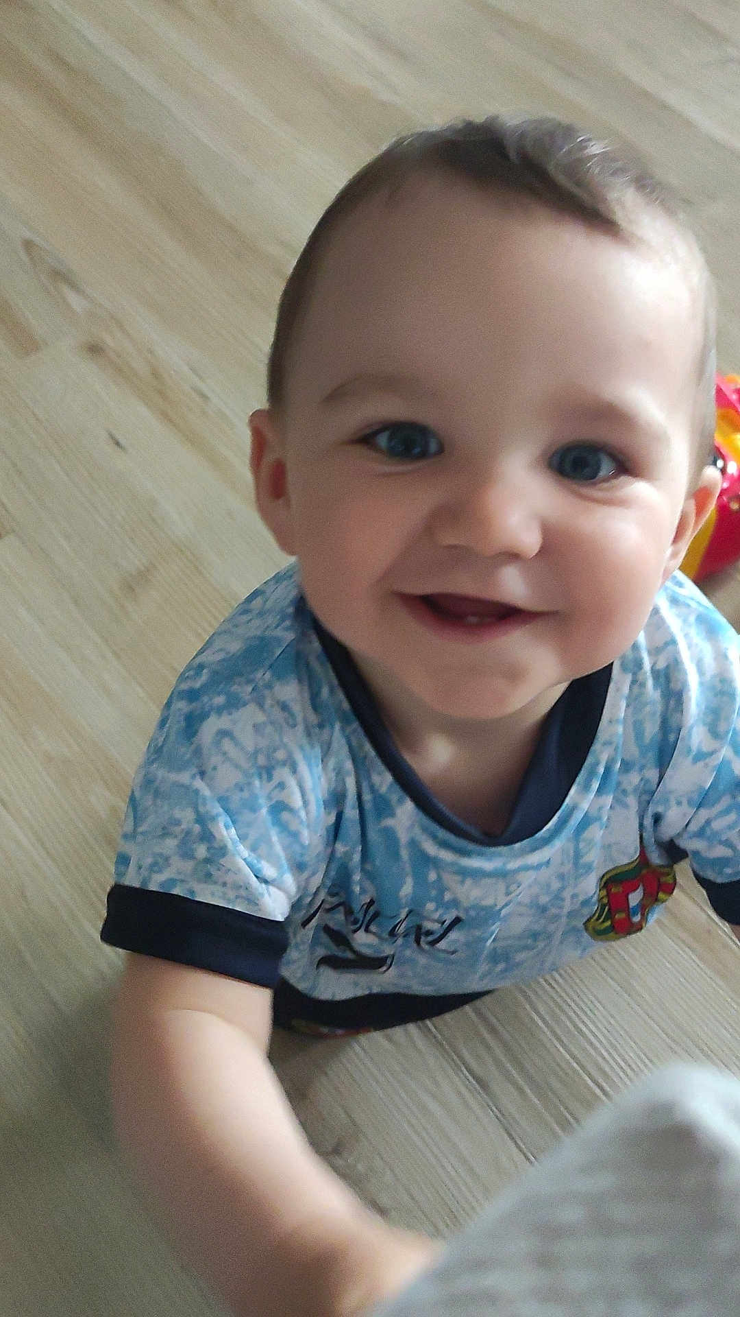 Lysio a rejoint le concours — aidez-le/la à gagner de superbes lots ! child, toddler, smiling, blue_eyes, short_hair, blue_shirt, patterned_clothing, indoor, wooden_floor, happy, cute, person, baby, portrait, young_child, cheerful, close_up, reaching, bright, casual