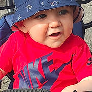 Lysio participe au concours pour gagner de l'argent avec cette photo : toddler, child, hat, bucket_hat, red_shirt, nike, outdoor, sunlight, stroller, handlebar, blue, shorts, happy, smiling, baby, person, casual_clothing, daylight, cute, seat