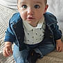 Lysio a rejoint le concours — aidez-le/la à gagner de superbes lots ! toddler, child, denim_jacket, jeans, sneakers, black_shoes, orange_logo, white_shirt, polo_shirt, indoor, blanket, beige_blanket, curly_hair, sitting, floor, couch, cozy, cute, portrait, baby