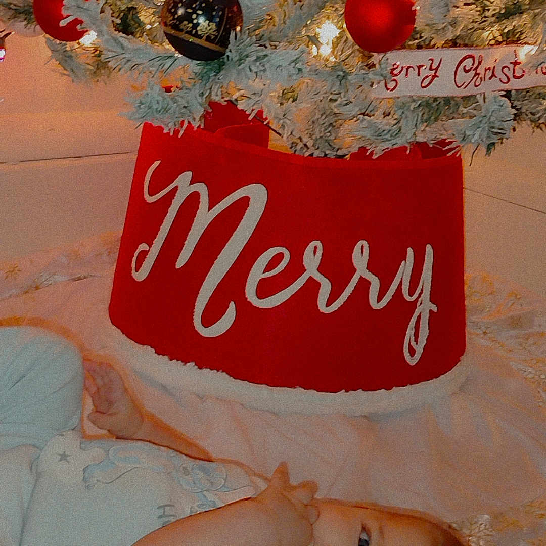 Ty'Lianna joined the competition — help win amazing prizes! baby, celebration, child, christmas_ornaments, christmas_tree, curious, cute, decor, festive, festivity, holiday_decorations, holiday_season, indoors, infant, lights, lying_down, red_tree_skirt, smiling, soft_surface, white_clothing