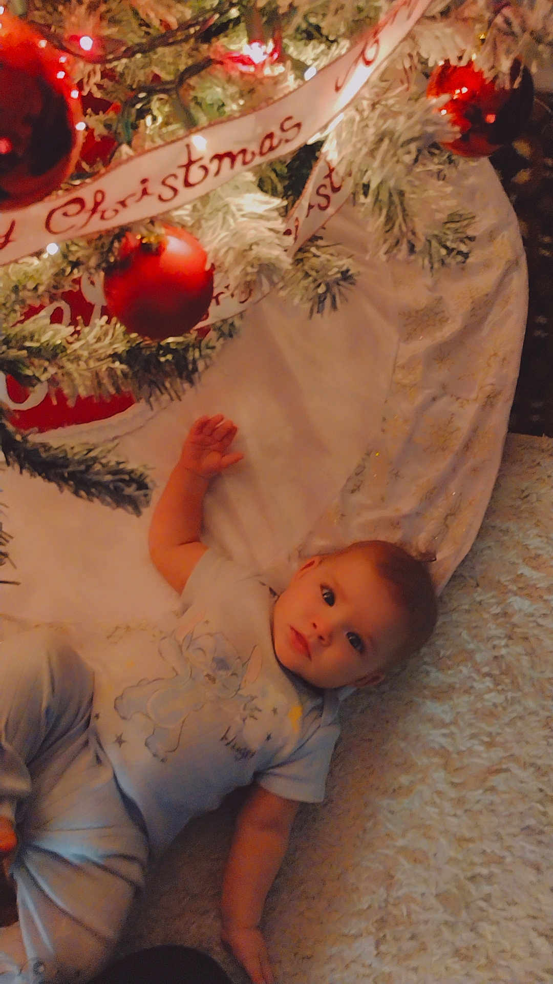 Ty'Lianna is registered to the contest to win money with this photo: baby, child, christmas_tree, ornament, red_ball, ribbon, carpet, holiday, festive, indoor, cozy, pajamas, infant, decoration, soft_lighting, winter, celebration, cute, toddler, face
