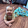 baby, child, floor, wood, blanket, tshirt, smile, happy, indoors, bottle, toy, couch, feet, arm, hand, face, expression, home, colorful, cozy