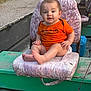 Eastyn joined the competition — help win amazing prizes! baby, child, orange_shirt, boat, seat, outdoor, green, cooler, curious, worn_seat, floral_pattern, cute, portrait, sitting, feet, hands, face, infant, daylight, casual
