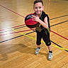 bags, ball, basketball, bench, boy, child, court_lines, goal_net, gymnasium, hardwood_floor, indoor, portrait, shadow, smile, sneakers, spectators, sports_uniform, team, wall, wood_floor