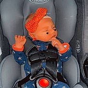 Lilly joined the competition — help win amazing prizes! baby, car_seat, graco, headband, onesie, sleeping, infant, child, safety_harness, orange, blue, floral_pattern, cute, peaceful, indoor, seat, person, toddler, face, hand