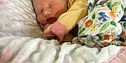 Lilly is registered to the contest to win money with this photo: baby, newborn, sleeping, blanket, floral_pattern, soft, cushion, baby_nest, pastel_colors, cozy, infant, clothing, peaceful, indoors, resting, cute, face, child, comfort, wrapped