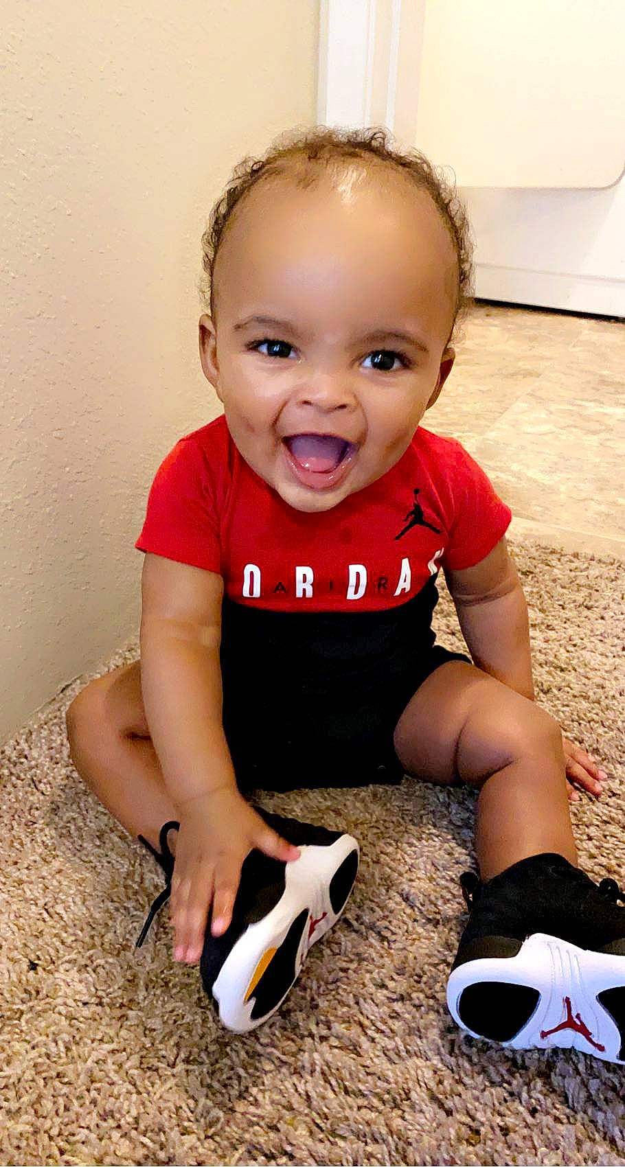 Khamari is registered to the contest to win money with this photo: baby, baby_toddler_clothing, child, face, finger, flooring, hairstyle, happy, human_leg, joint, knee, mouth, person, pink, sitting, skin, sleeve, smile, t_shirt, toddler