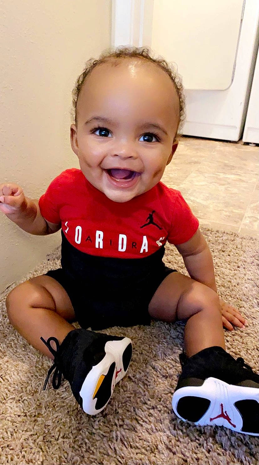 Khamari joined the competition — help win amazing prizes! baby_toddler_clothing, child, cup, eye, facial_expression, flooring, hairstyle, happy, joy, knee, leg, person, pink, shorts, skin, sleeve, smile, standing, tableware, thigh