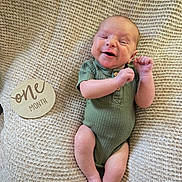 Rhett joined the competition — help win amazing prizes! baby, infant, smiling, green_onesie, blanket, wooden_sign, one_month, cute, happy, newborn, portrait, lying_down, skin, hand, foot, buttoned_clothing, texture, cozy, milestone, baby_girl