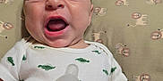 Rhett is registered to the contest to win money with this photo: baby, bottle, child, closeup, cushion, cute, dinosaur_print, expression, face, feeding, hand, human, indoors, infant, lion_pattern, mouth_open, newborn, onesie, person, sleepwear