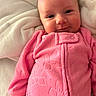 Alaina joined the competition — help win amazing prizes! baby, infant, smile, pink_clothing, onesie, blanket, soft_texture, portrait, face, child, cute, happy, lying_down, indoors, closeup, warm, comfort, skin, head, hands