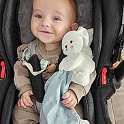 Adriann a rejoint le concours — aidez-le/la à gagner de superbes lots ! baby, infant, smiling, car_seat, plush_toy, stuffed_bunny, pacifier, safety_belt, buckle, blue_blanket, hand, adorable, portrait, cozy, seat_padding, soft_toy, clothing, infant_outfit, eyes, cute