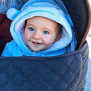 Adriann participe au concours pour gagner de l'argent avec cette photo : baby, child, infant, stroller, pram, hood, blue_hoodie, smile, happy, blue_eyes, cheeks, close_up, portrait, cozy, clothing, seat, outdoors, sunlight, candid, adorable