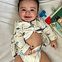 Manuel joined the competition — help win amazing prizes! baby, book, child, closeup, clothing, cute, diaper, face, hand, happy, indoors, infant, lying_down, onesie, pacifier, playful, smiling, toy, white_background, young