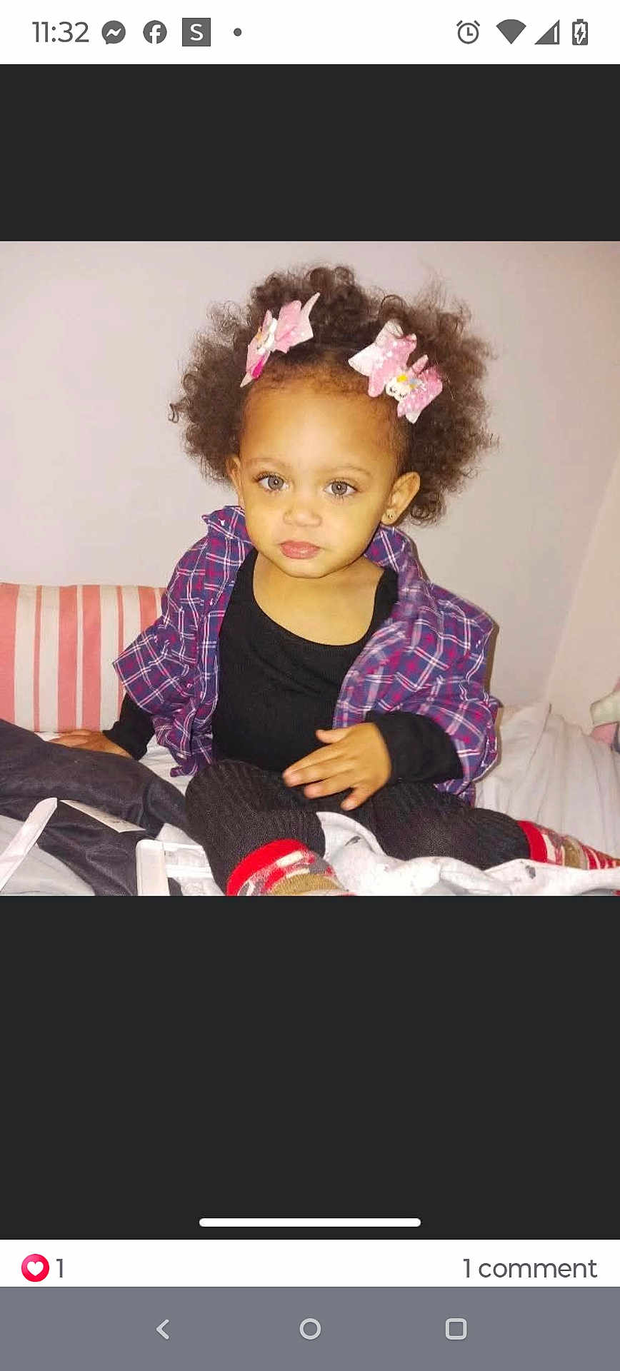 Violet Rose is registered to the contest to win money with this photo: toddler, child, curly_hair, pink_bows, plaid_shirt, black_top, sitting, bed, striped_pillow, indoors, young_child, person, casual_clothing, portrait, cute, looking_at_camera, small_child, light_skin, cozy, home