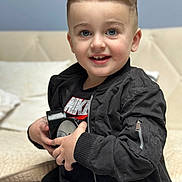 Edior joined the competition — help win amazing prizes! bodypart, boy, child, clothing, coat, couch, face, finger, furniture, hand, happy, head, jacket, male, pants, person, photography, portrait, sitting, smile