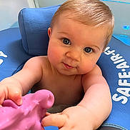 Arthur a rejoint le concours — aidez-le/la à gagner de superbes lots ! baby, child, blue_eyes, floatation_device, water, toy, pink_toy, arm, hand, face, skin, hair, infant, sitting, closeup, playful, curious, indoors, child_in_water, safe