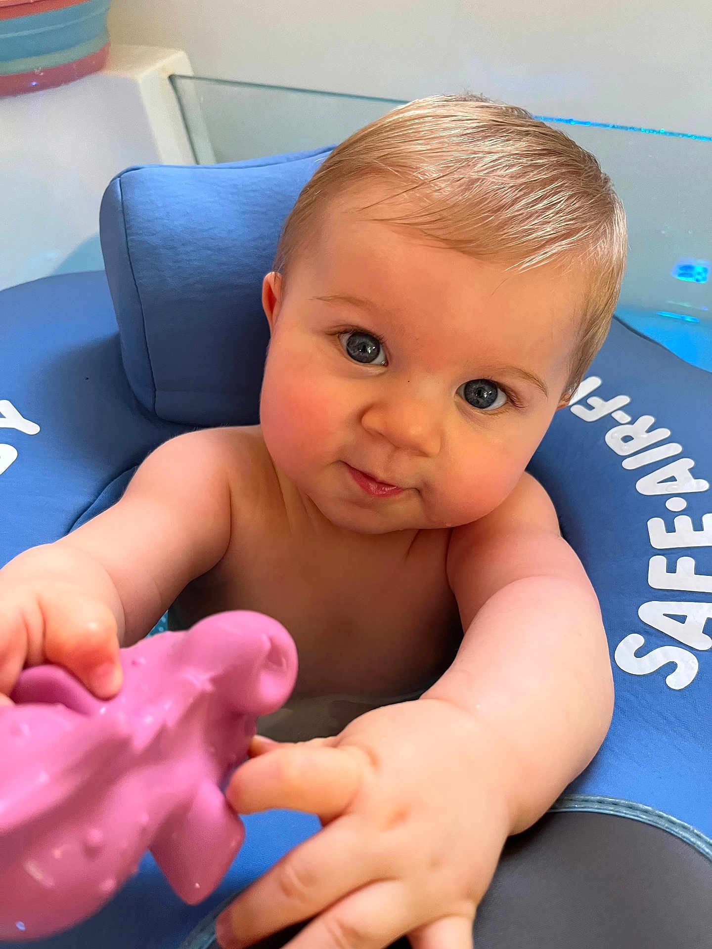 Arthur a rejoint le concours — aidez-le/la à gagner de superbes lots ! baby, child, blue_eyes, floatation_device, water, toy, pink_toy, arm, hand, face, skin, hair, infant, sitting, closeup, playful, curious, indoors, child_in_water, safe