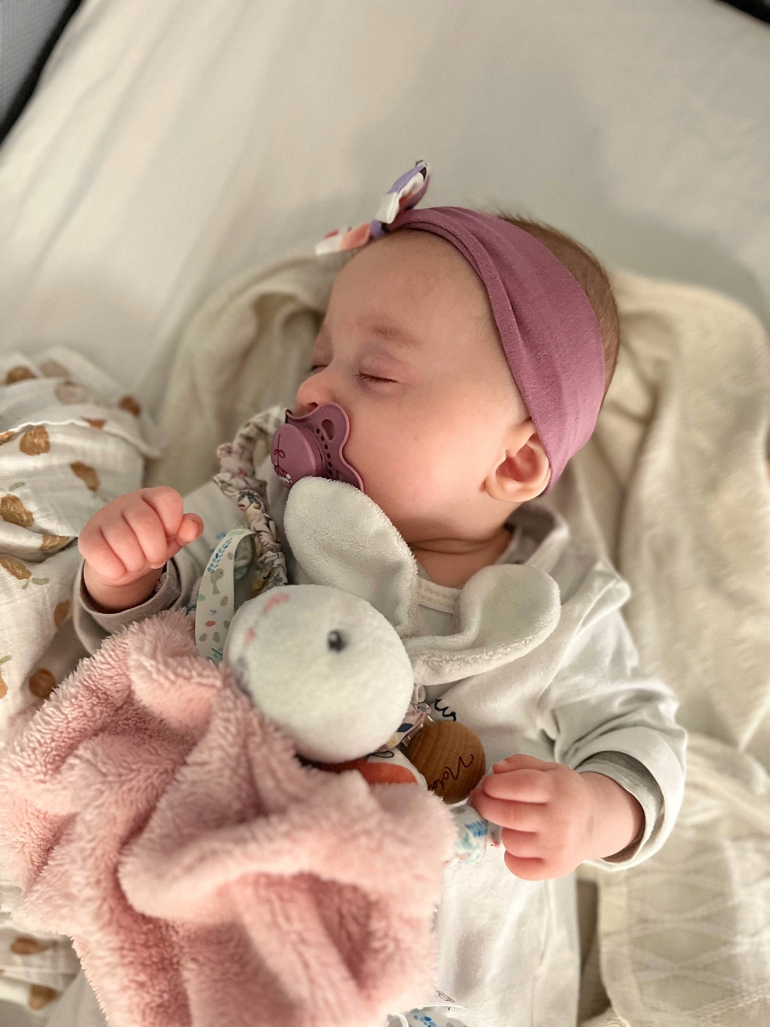 Nola a rejoint le concours — aidez-le/la à gagner de superbes lots ! baby, baby_products, baby_sleeping, baby_toddler_clothing, beanie, cap, cheek, child, comfort, doll, fur, knit_cap, linens, outerwear, person, pink, sitting, skin, sleeve, textile