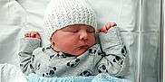 Archie is registered to the contest to win money with this photo: baby, newborn, sleeping, hat, knitted_hat, onesie, panda_pattern, blanket, blue_blanket, hospital, bassinet, infant, cute, peaceful, clothing, child, face, resting, bed, soft
