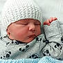baby, newborn, sleeping, hat, knitted_hat, onesie, panda_pattern, blanket, blue_blanket, hospital, bassinet, infant, cute, peaceful, clothing, child, face, resting, bed, soft