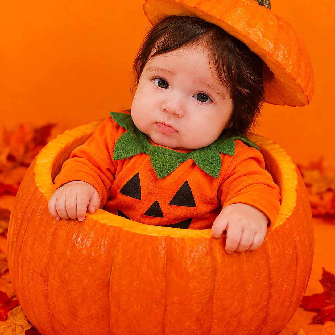 Marcela joined the competition — help win amazing prizes! baby, child, pumpkin, halloween, costume, orange, portrait, face, infant, sitting, autumn, leaves, jack_o_lantern, hat, smiling, indoors, seasonal, photography, cute, holiday
