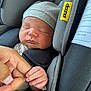 newborn, baby, sleeping, car_seat, hat, hand, finger, close_up, infant, child, cozy, soft, gray, rest, cute, tenderness, family, bond, comfort, peaceful