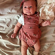 Elora is registered to the contest to win money with this photo: baby, infant, child, romper, headband, socks, bed, blanket, fabric, clothing, cute, sleepwear, person, skin, hand, foot, lying_down, soft, indoors, portrait